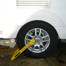 Load image into Gallery viewer, Milenco Radkralle Compact für 12-16" Räder. Inklusive Sicherheitsschloss. Farbe: Gelb. Reallife Bild mit Rad seitlich.